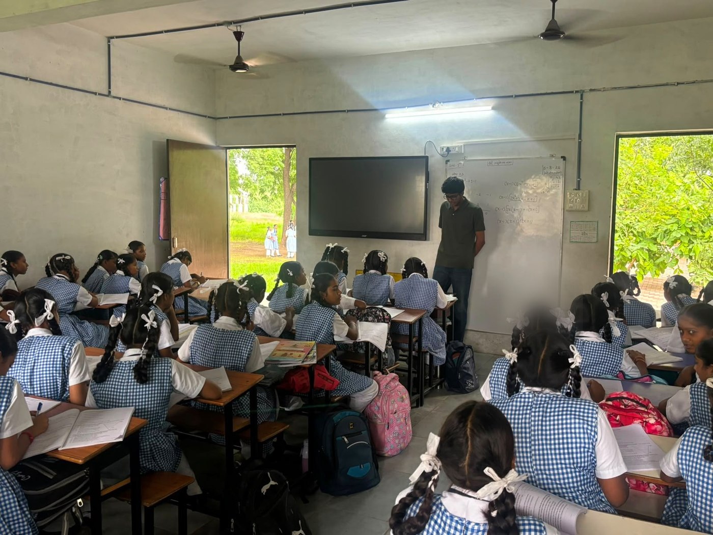 Rishabh teaching a math problem on the classroom smart board